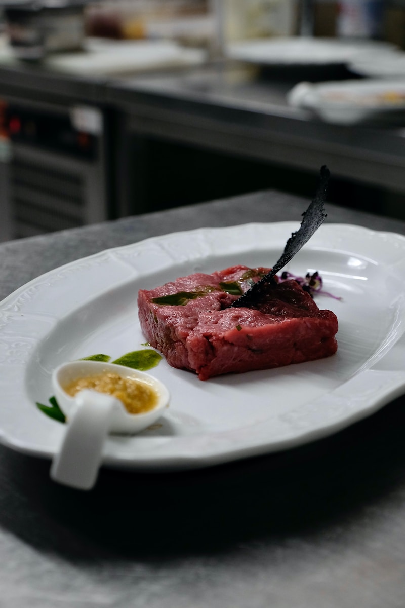 a white plate topped with a piece of meat